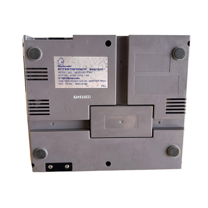 Console Nintendo NES avec manette et câbles, vue détaillée de l’exemplaire