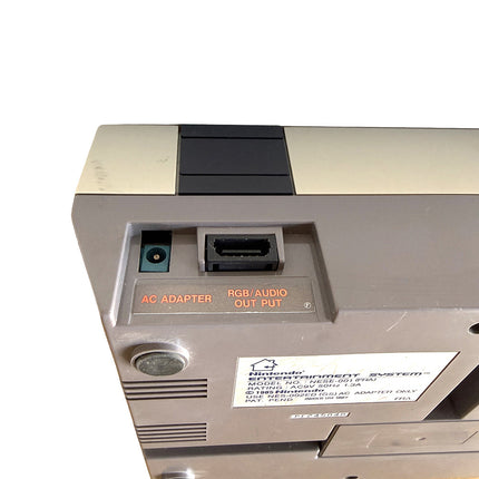Console Nintendo NES avec manette et câbles, vue détaillée de l’exemplaire